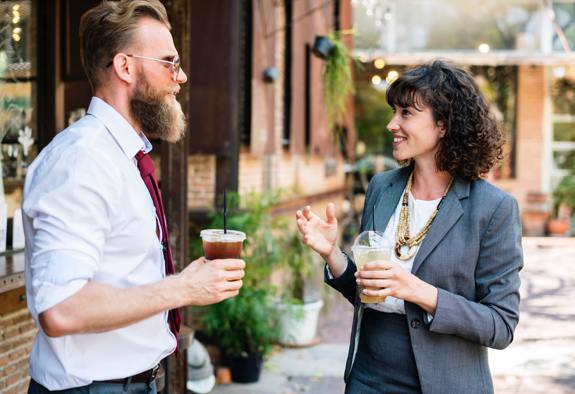 Man and woman conversing while drinking coffee. 